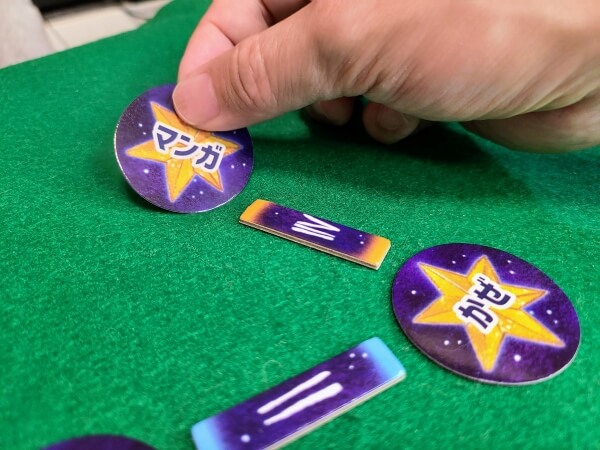 Person placing a 'manga' card in the SIGN play area