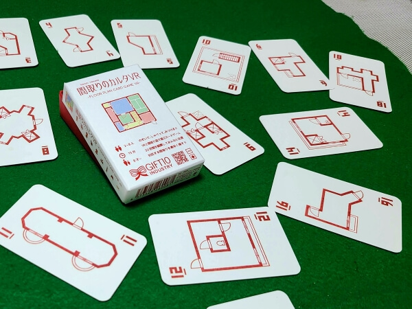 Cards from Floor Plan Card Game VR scattered across a green felt mat, with the box in the center