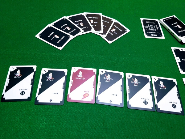 BATTING CARDGAME cards spread out on a green felt cloth, arranged to show the different pitches and swings available.